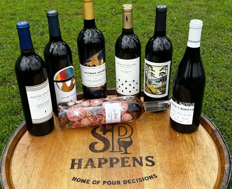 Wine bottles arranged on a Sip Happens branded barrel